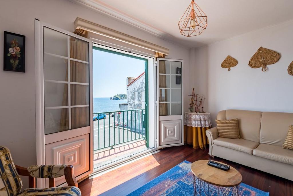 ein Wohnzimmer mit Blick auf das Meer in der Unterkunft WelcomeBuddy - Berço do Infante Sea View in Vila Franca do Campo