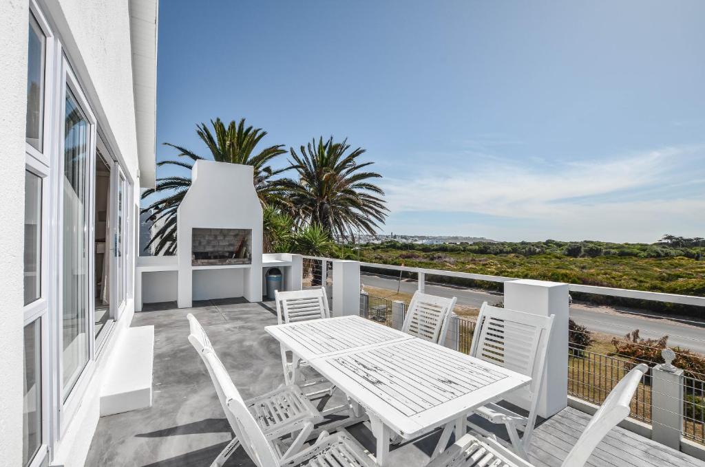a patio with a table and chairs on a balcony at 9 on Dolfyn in Yzerfontein