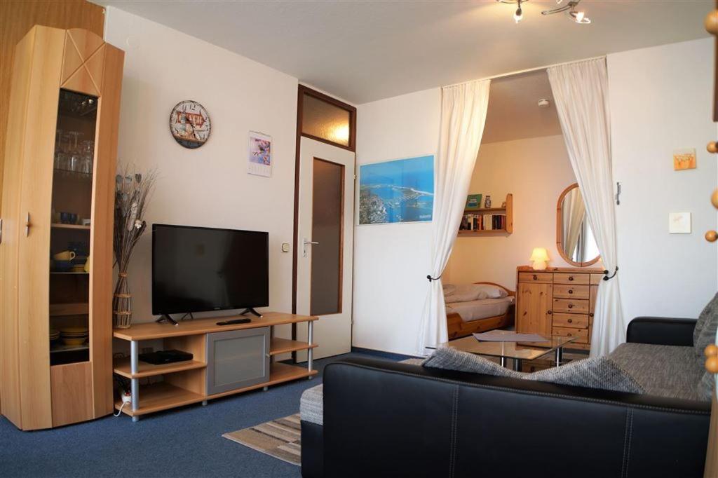 uma sala de estar com um sofá e uma televisão de ecrã plano em Ferienpark - Haus P, App 0P0305 em Heiligenhafen