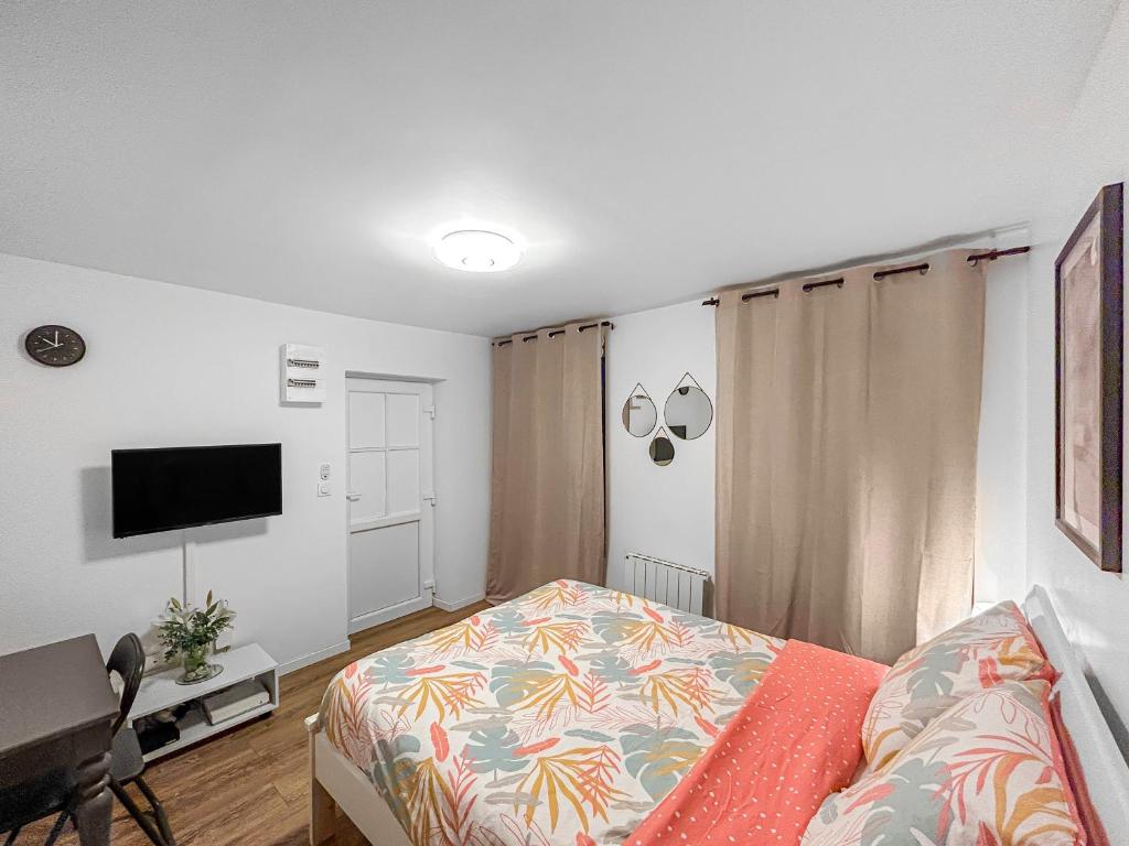 a bedroom with a bed and a flat screen tv at DARETSOLUTION in Essômes-sur-Marne