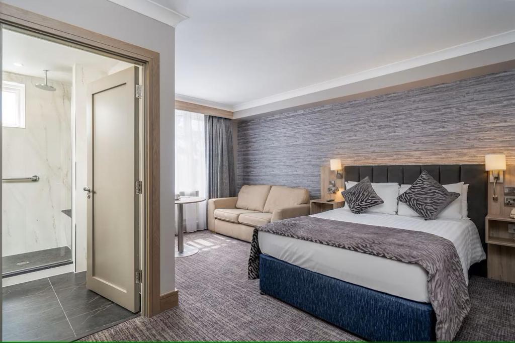 a hotel room with a bed and a couch at Rochestown Lodge Hotel in Dun Laoghaire