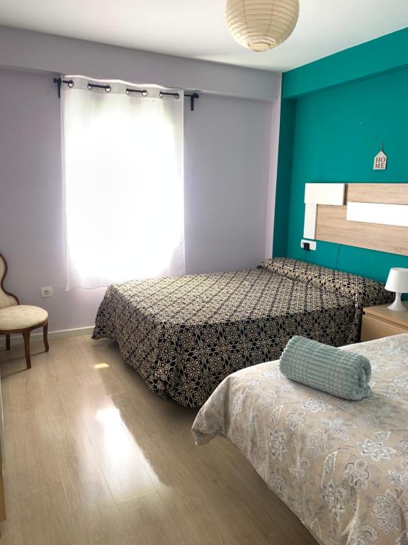 1 dormitorio con 2 camas y ventana en Bonito Apartamento en la Macarena en Sevilla