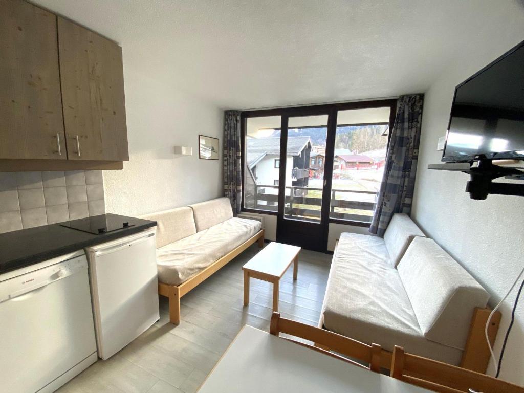 ein kleines Wohnzimmer mit einem Sofa und einem Tisch in der Unterkunft Studio Morillon 1100, 1 pièce, 4 personnes - FR-1-412-3 in Morillon