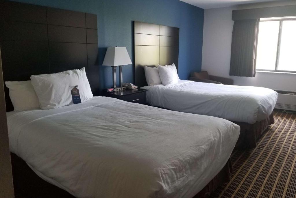 Baymont Inn & Suites Richmond في Richmond: غرفة فندقية بسريرين ونافذة