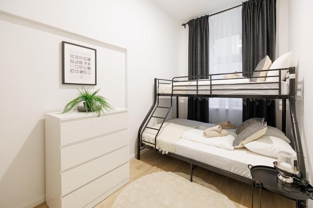 1 Schlafzimmer mit 2 Etagenbetten und einer Kommode in der Unterkunft Central City Style Rooms by Home2 in Wien