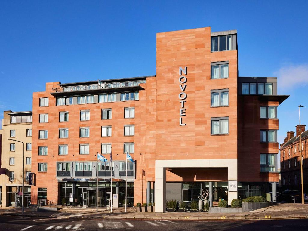 un edificio de ladrillo rojo con un cartel. en Novotel Edinburgh Centre, en Edimburgo