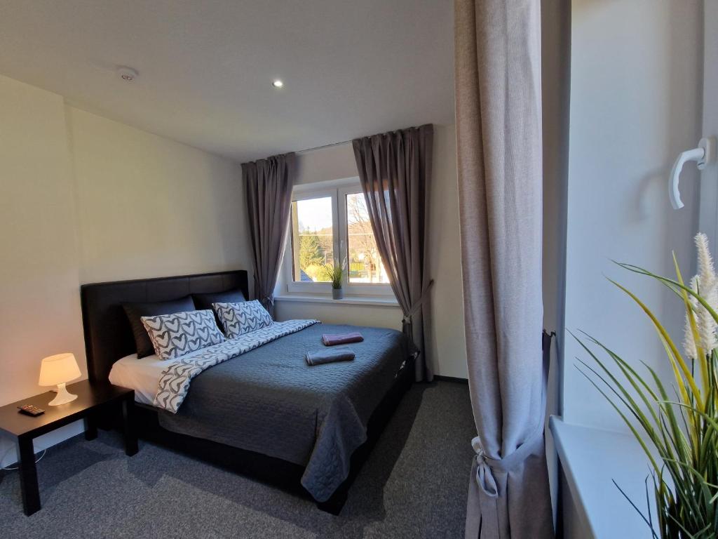 a small bedroom with a bed and a window at Apartament rodzinny- Willa Lawenda in Rytro