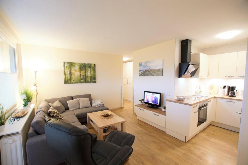 sala de estar con sofá y cocina en Ferienpark - Haus Q, App 0QEG07, en Heiligenhafen