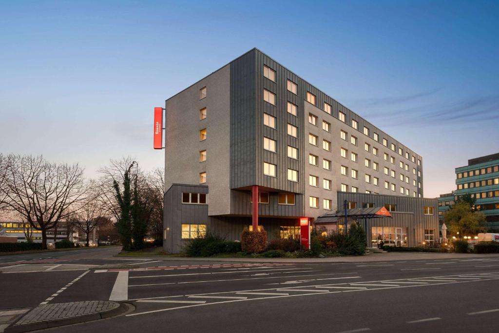 a large building on a city street with a road at Ramada by Wyndham Bottrop City in Bottrop
