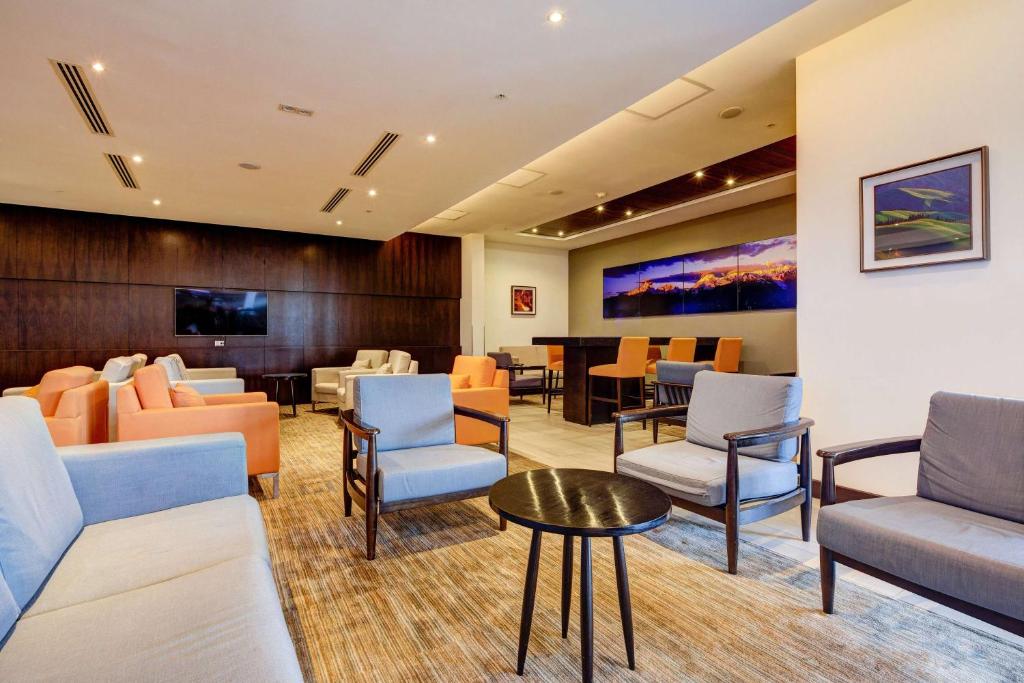 a waiting room with couches and chairs and a table at La Quinta by Wyndham Santiago Aeropuerto in Santiago