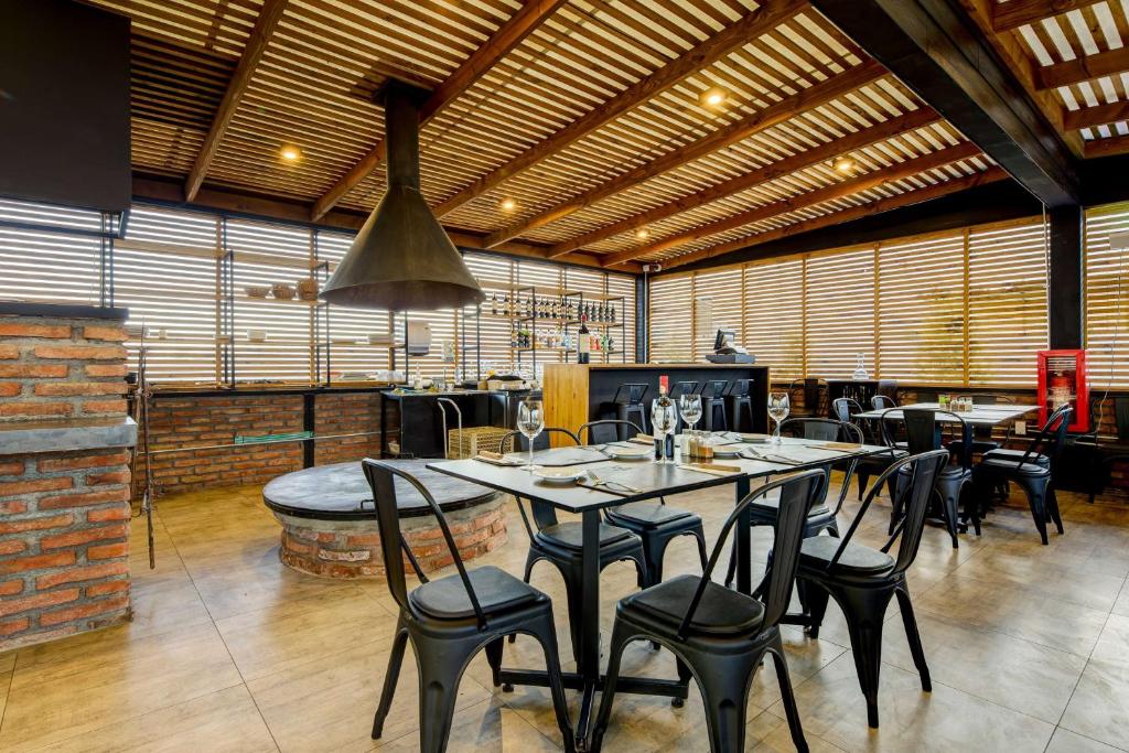 a restaurant with tables and chairs in a room at La Quinta by Wyndham Santiago Aeropuerto in Santiago