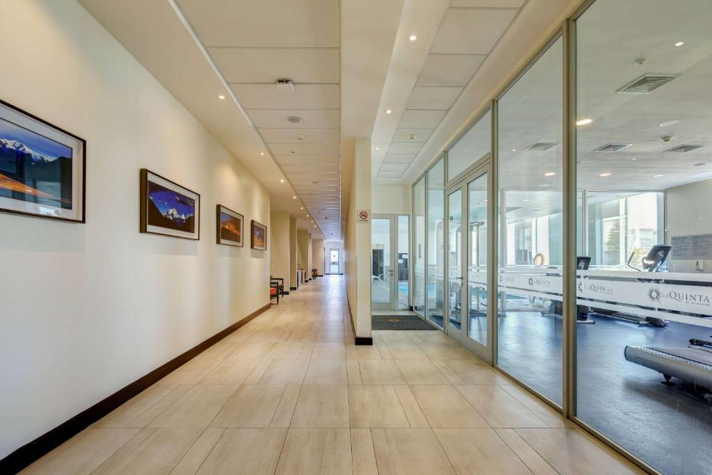 an empty hallway in a building with glass walls at La Quinta by Wyndham Santiago Aeropuerto in Santiago