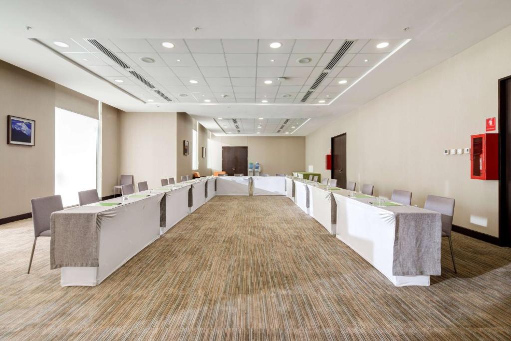 a conference room with white tables and chairs at La Quinta by Wyndham Santiago Aeropuerto in Santiago