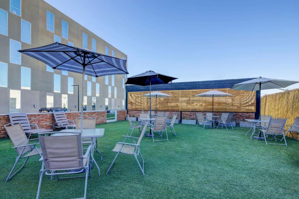 a group of tables and chairs with umbrellas at La Quinta by Wyndham Santiago Aeropuerto in Santiago