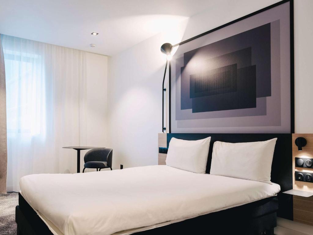 une chambre d'hôtel avec un lit et une chaise dans l'établissement ibis Rouen Centre Rive Droite Pasteur, à Rouen