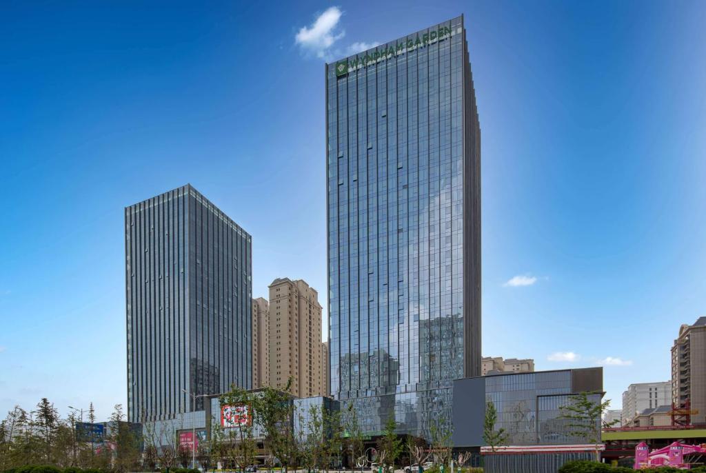 a tall building with many windows in a city at Wyndham Garden Lanzhou West Railway Station in Lanzhou