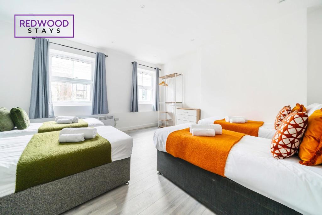 um quarto com duas camas e uma placa que lê pau-brasil em BRAND NEW, 2 Bed 1 Bath, Modern Town Center Apartment, FREE WiFi & Netflix By REDWOOD STAYS em Aldershot