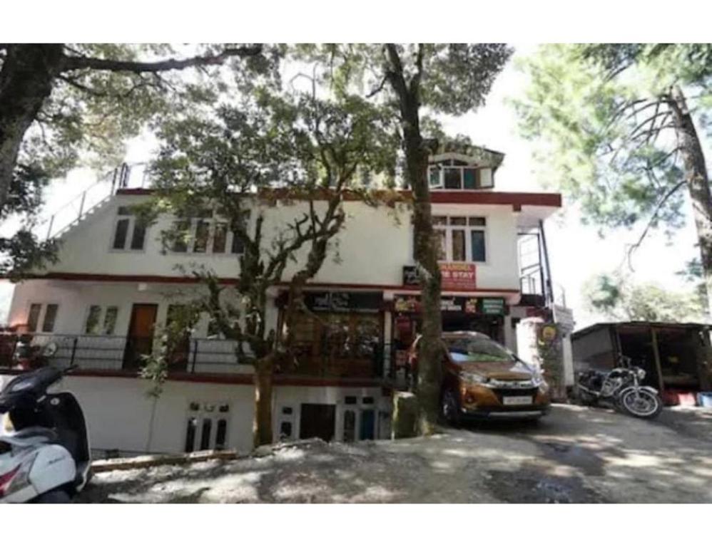 a building with a car parked in front of it at Chandel Home Stay , Shimla in Shimla