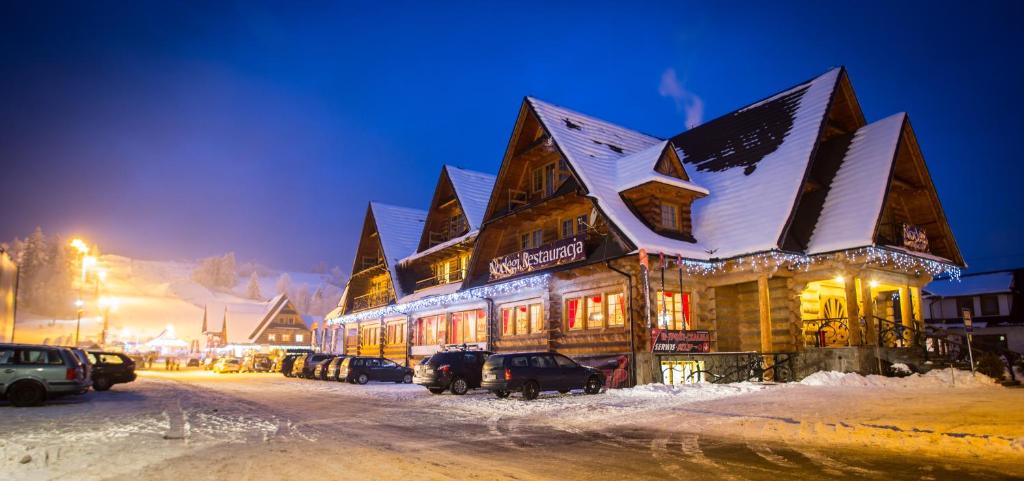 un bâtiment recouvert de neige la nuit dans l'établissement Witowianka, à Witów