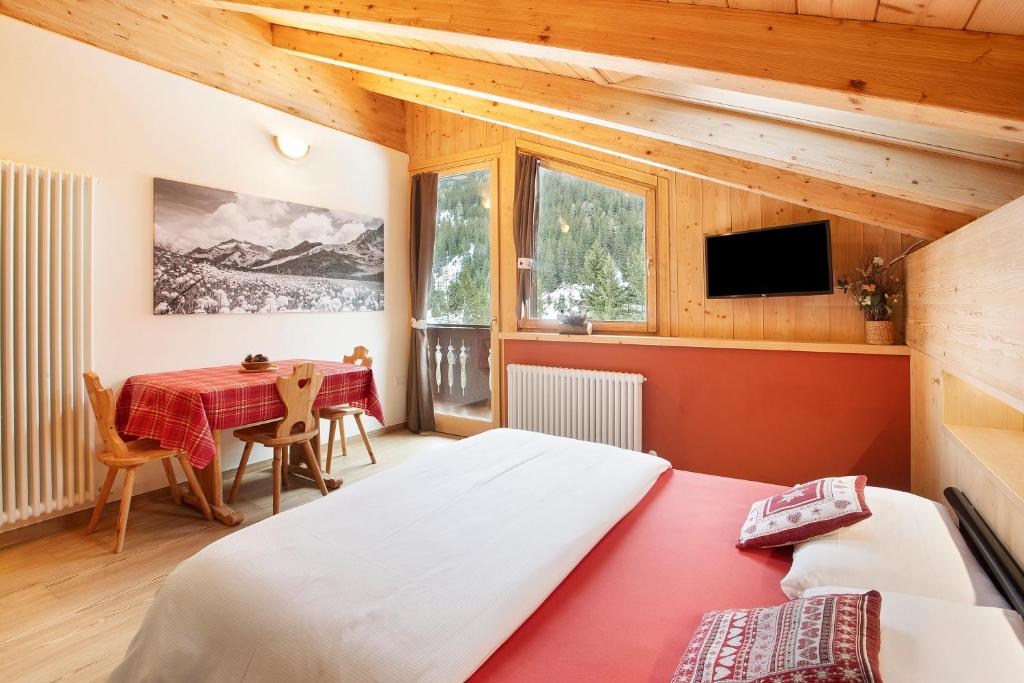 1 dormitorio con 2 camas y mesa en Chalet Primula 14 en Santa Caterina Valfurva