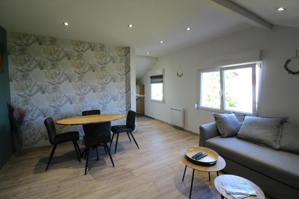 ein Wohnzimmer mit einem Sofa und einem Tisch in der Unterkunft Au Coin des Fées in Les Forges