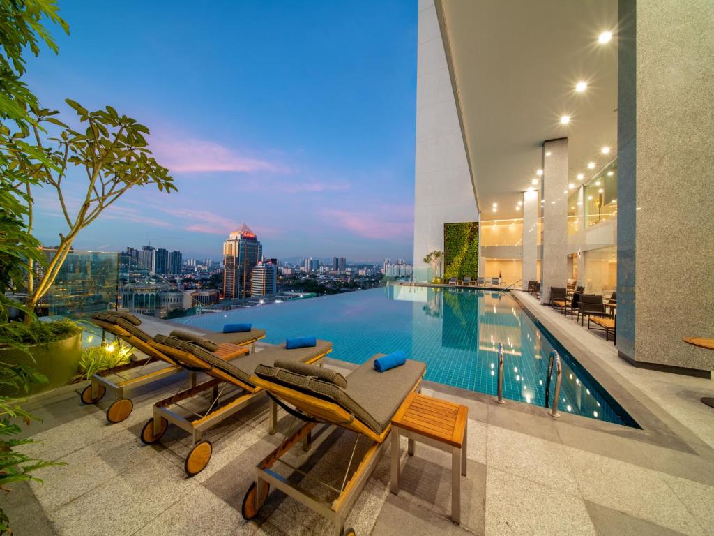 - une piscine avec des chaises longues et une vue sur la ville dans l'établissement Sunway Sanctuary - Seniors Hotel & Residences, à Subang Jaya