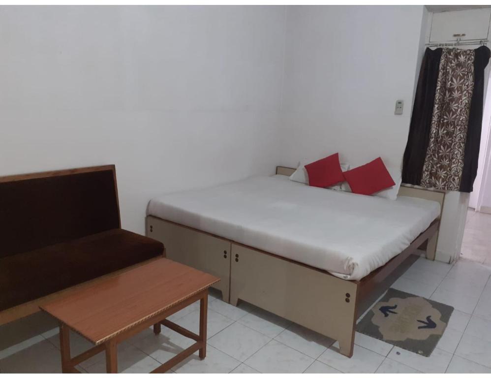 a room with a bed and a couch and a table at Hotel Vishal, Gaya in Gaya