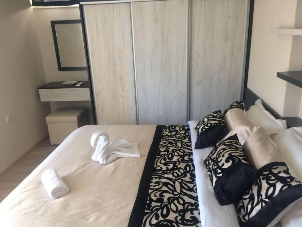 a bedroom with a large white bed with black and white pillows at Luxury Two Bedroom Flat in Blagoevgrad