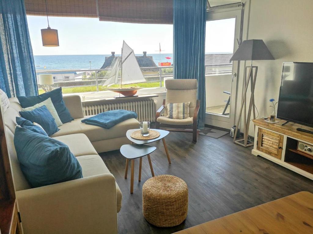 un soggiorno con divano e vista sull'oceano di Strandhotel Wohnung 16 a Dahme