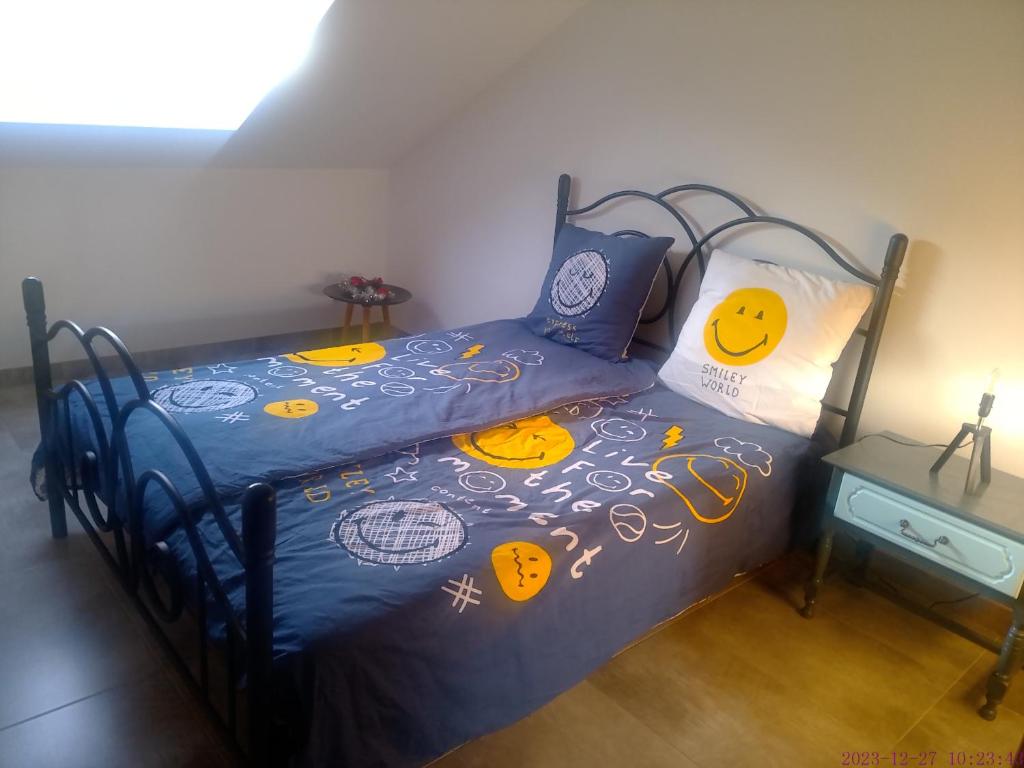 1 dormitorio con 1 cama con edredón y almohadas azules en L'ECUREUIL, 