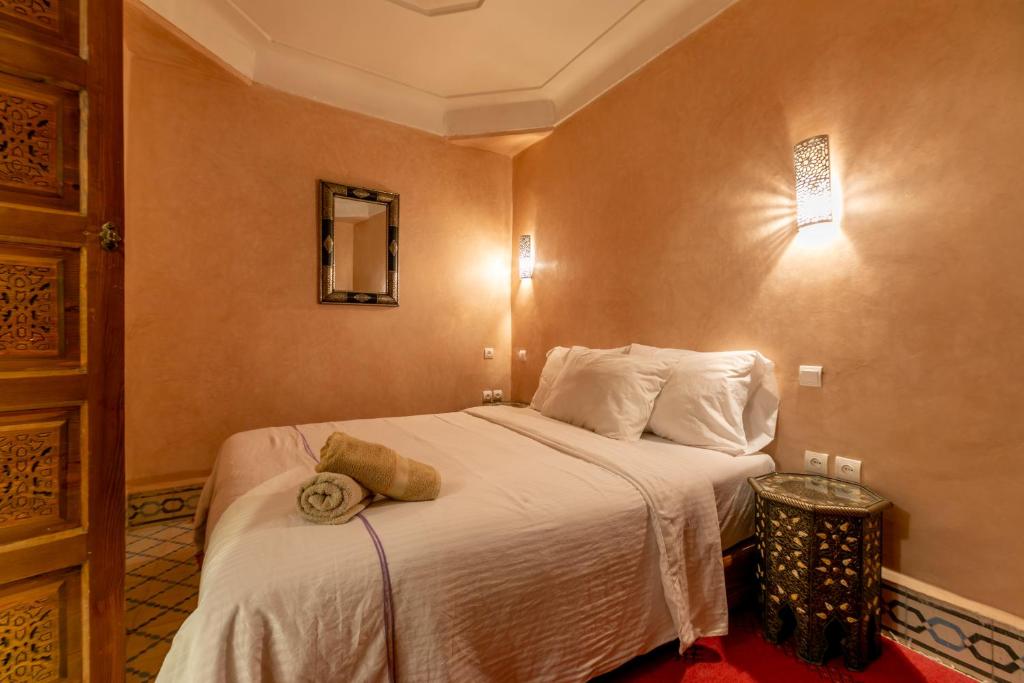 una camera d'albergo con un letto con un cappello sopra di Riad Dali a Marrakech
