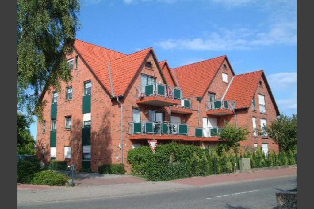 ein großes Backsteingebäude mit einem orangefarbenen Dach in der Unterkunft Villa Seewind Wohnung 9 in Dahme