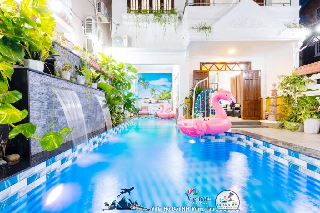una piscina con inflables rosas en una casa en VILLAGES ĐĂNG KHOA Hồ Bơi SÂN VƯỜN BBQ en Vung Tau