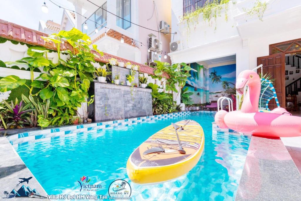 une piscine avec un radeau et des nouilles roses gonflables dans l'établissement VILLAGES ĐĂNG KHOA BBQ Vũng Tàu, à Vung Tau