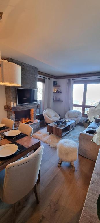 een woonkamer met een bank en een tafel bij Arcs 1950 Appartement Luxe type chalet 5 à 7 personnes Vue imprenable sur le Montblanc skis aux pieds in Arc 1950