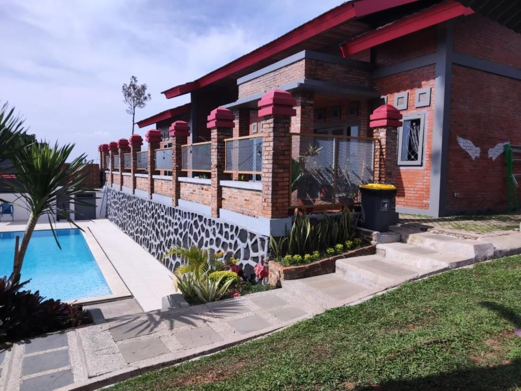a house with a swimming pool in front of it at Villa Forest Puncak in Tagalbato
