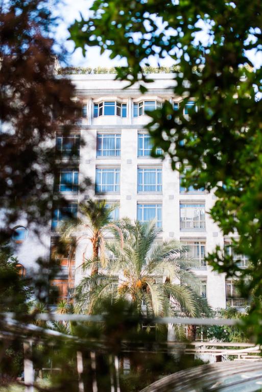 a tall white building with palm trees in front of it at VP Madroño in Madrid