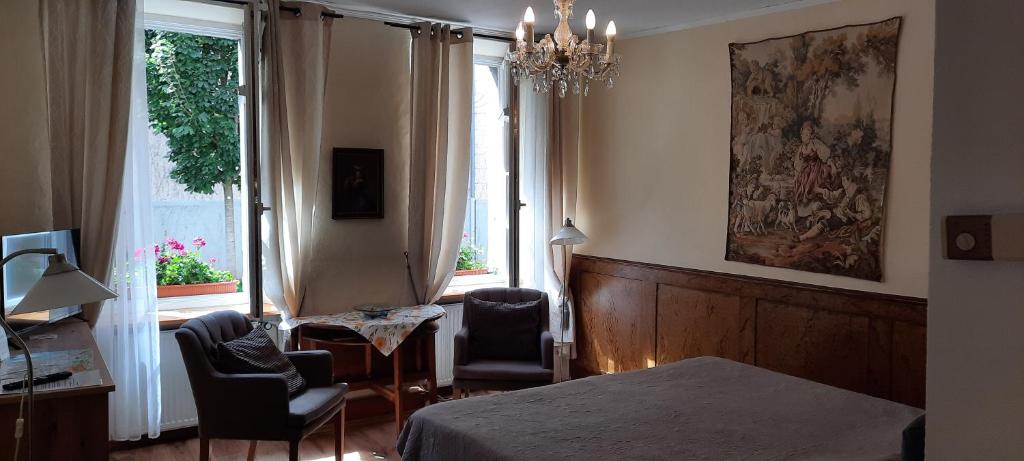 a bedroom with a bed and two chairs and a window at Altstadtapartment Rochusstraße in Mainz