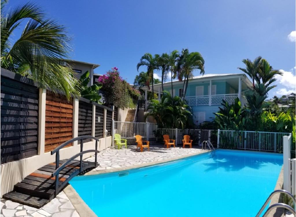 a swimming pool in front of a house at PARADIS TURQUOISE LOCATIONS in Les Trois-Îlets