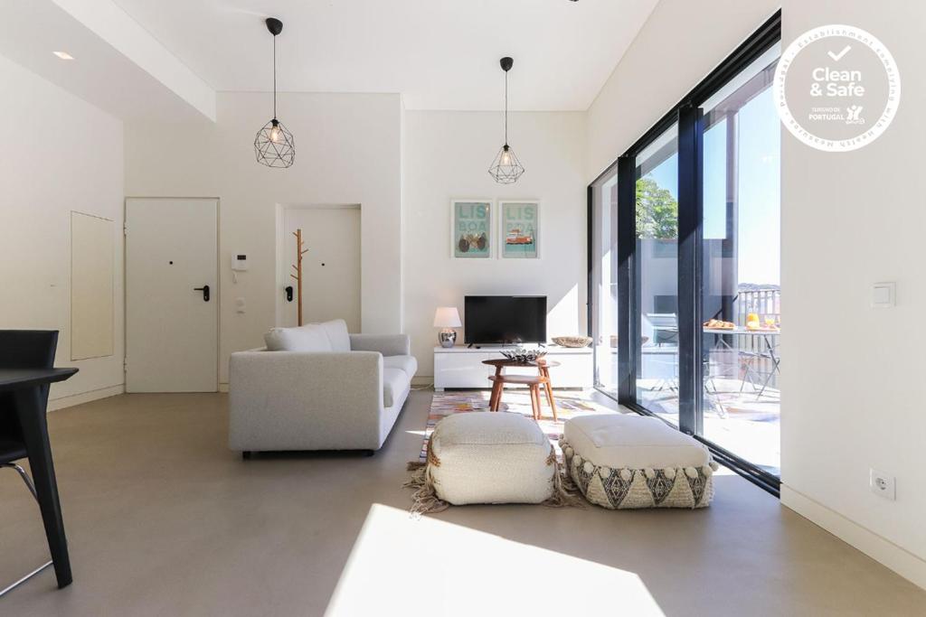 een woonkamer met witte meubels en grote ramen bij Avenida Liberdade Premium I by Homing in Lissabon