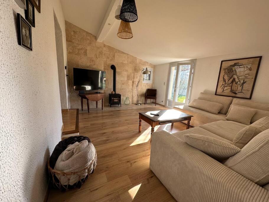 uma sala de estar com um sofá e uma mesa em Maison avec jardin em Malemort-du-Comtat