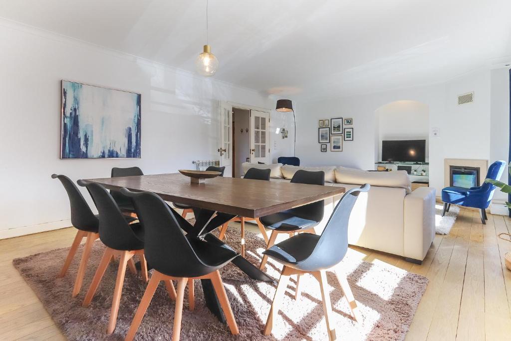 a living room with a wooden table and chairs at Laranjeiras Deluxe by Homing in Lisbon
