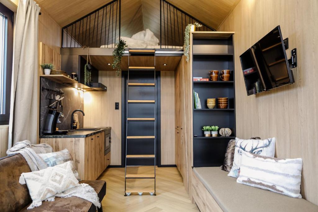 a tiny house with a kitchen and a living room at Luxe Tiny House op minicamping in Waarde in Waarde