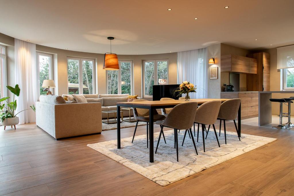 kuchnia i salon ze stołem i krzesłami w obiekcie LES GITES DE LA KARLSMUHLE w mieście Haguenau
