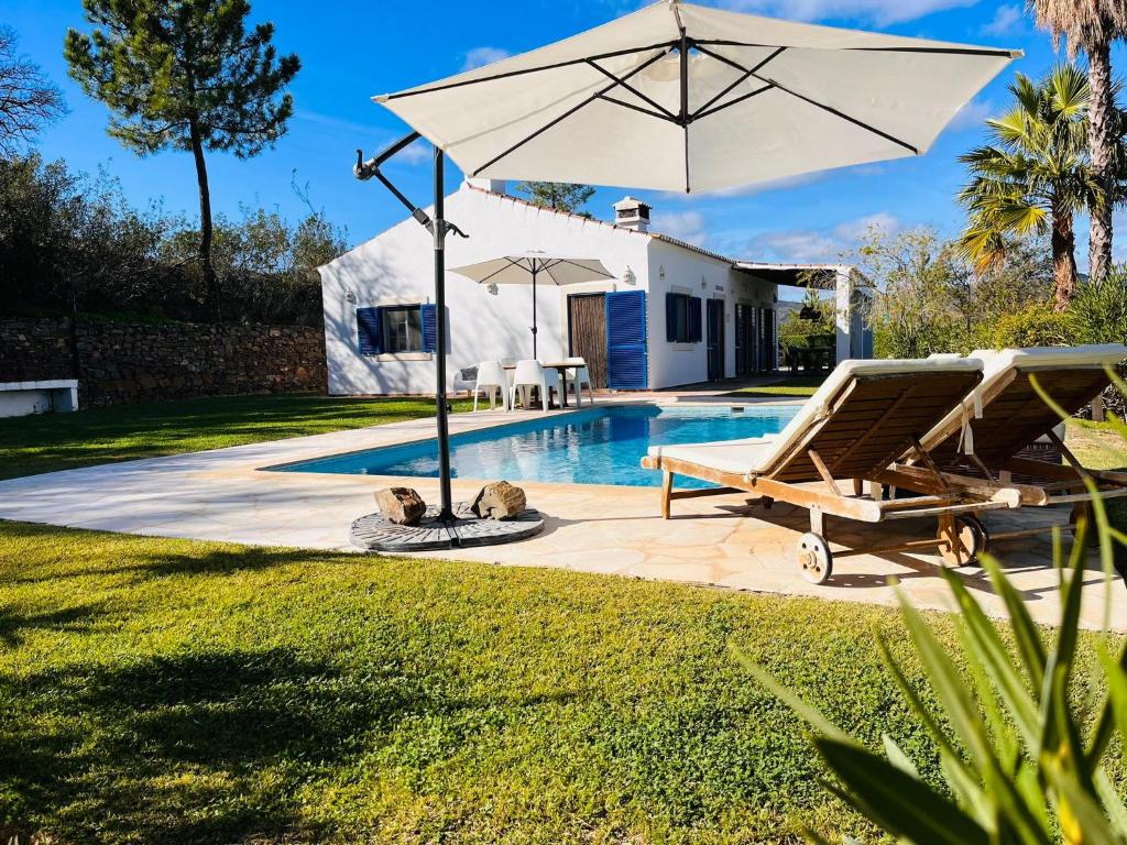 a patio with an umbrella and a pool at Villa a Vida 