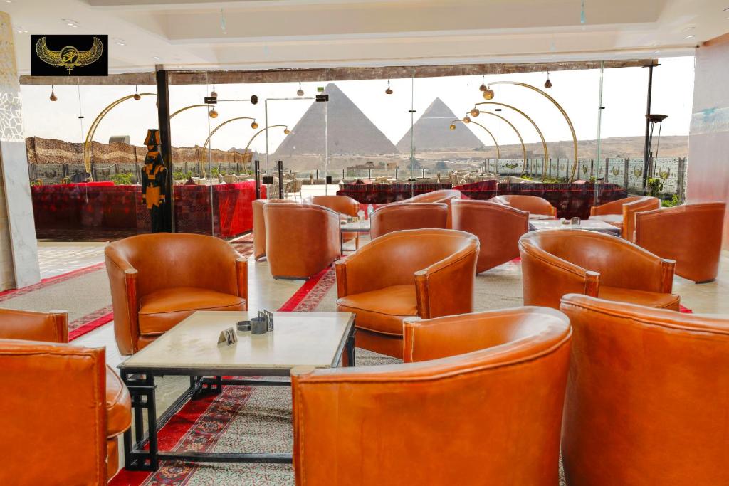 New Comfort Inn Giza في القاهرة: مطعم بالكراسي والطاولات والاهرامات