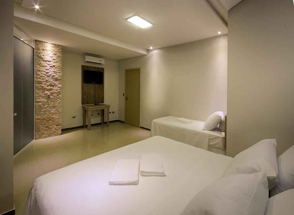 Habitación de hotel con 2 camas y TV en Hotel Iguassu Inn, en Foz do Iguaçu