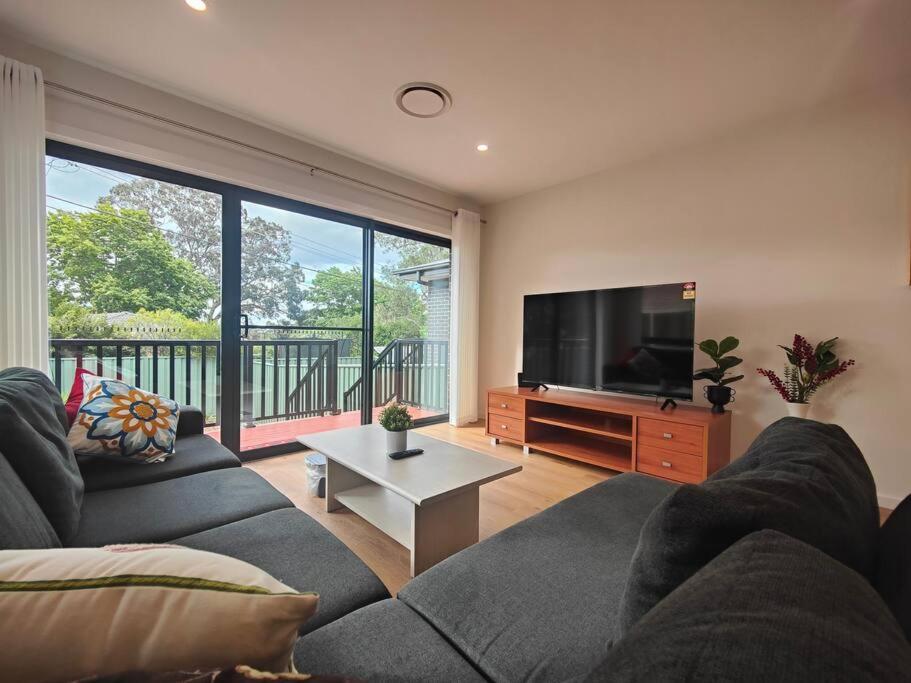 a living room with a couch and a flat screen tv at Brand new settled beautiful house，near shops in Weetangerra