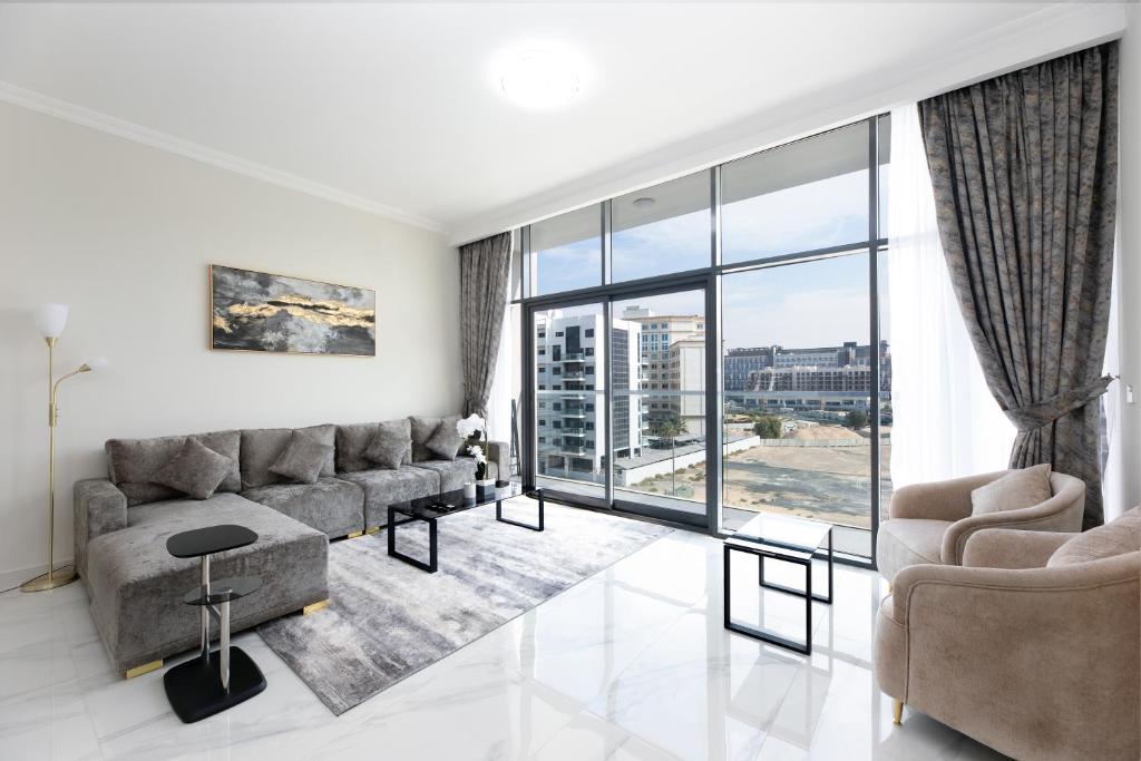 a living room with a couch and a large window at Spacious 3BR Apartment Near Miracle Garden in Dubai