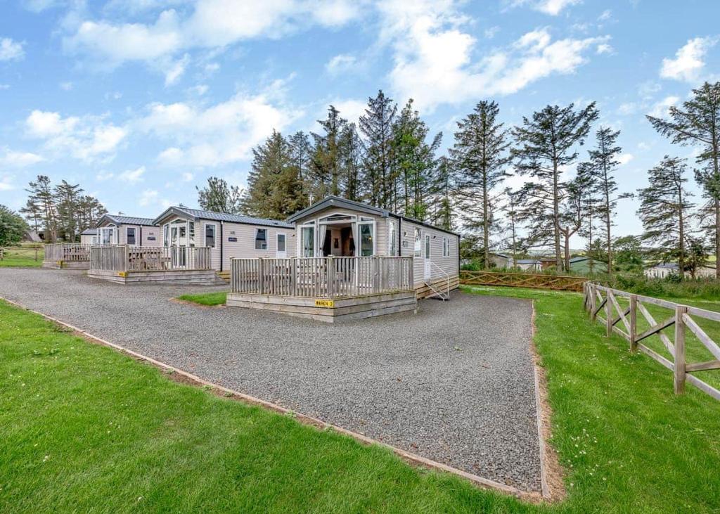 a large home with a house in a field at Waren Caravan Park in Bamburgh